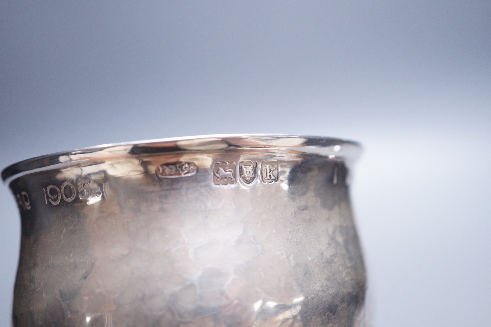 An Edwardian Arts & Crafts planished silver chalice, by Ramsden & Carr, inscribed ' I was wrought for Henry S. Tuke in the year 1905', with pierced stem, on circular foot, London, 1905, 12.3cm, 181 grams, the base inscri
